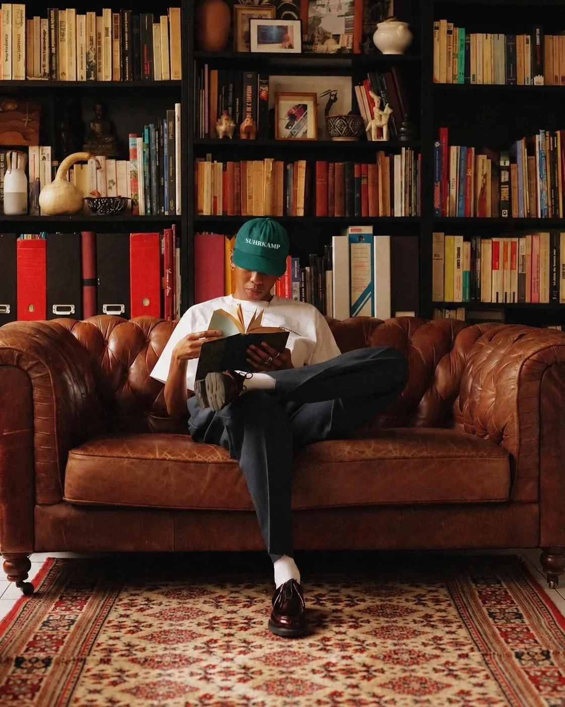 Leser mit Cap auf einem Ledersofa